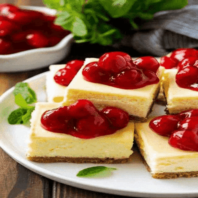 a white plate topped with cheesecake and cherries