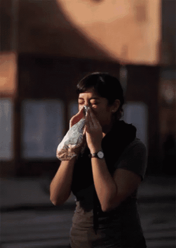 a woman blowing her nose with a bag of nuts