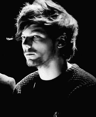 a man with long hair and a beard is wearing a black sweater