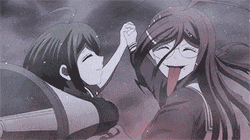 a couple of anime girls are standing next to each other and one of them is sticking her tongue out .
