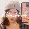 a woman wearing a beanie is taking a selfie with a cell phone .