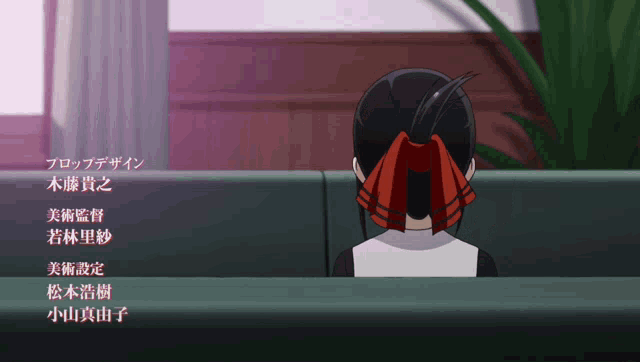 a girl with a red ribbon in her hair is sitting in a chair