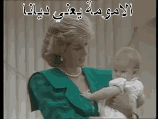 a woman in a green dress is holding a baby in her arms in arabic writing .