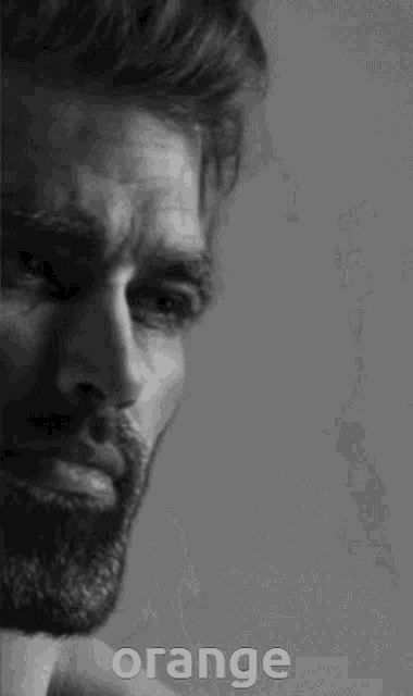 a man with a beard and the word orange on the bottom right