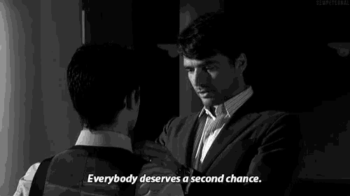 a man in a suit is talking to another man in a black and white photo with the caption everybody deserves a second chance