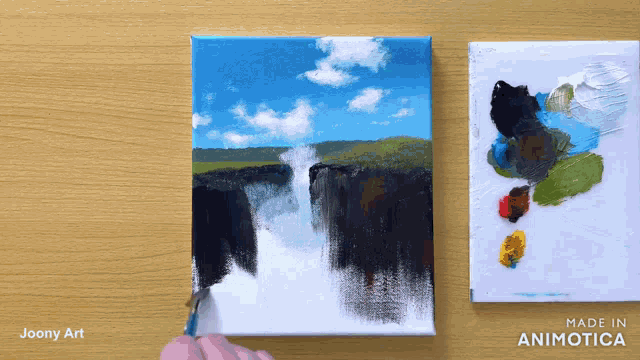 a painting of a waterfall is being painted on a canvas by joony art