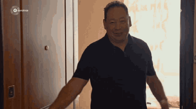 a man in a black shirt is standing in front of a door with eurotvos written on it