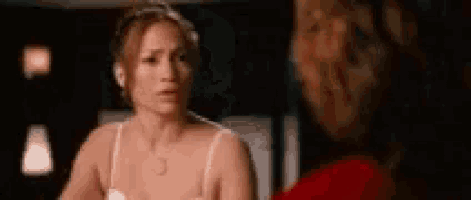 a woman in a bra is talking to another woman in a red shirt .