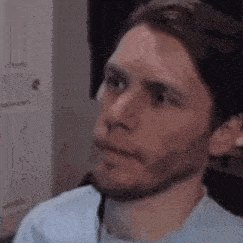 a man with a beard is making a funny face while sitting in front of a computer .
