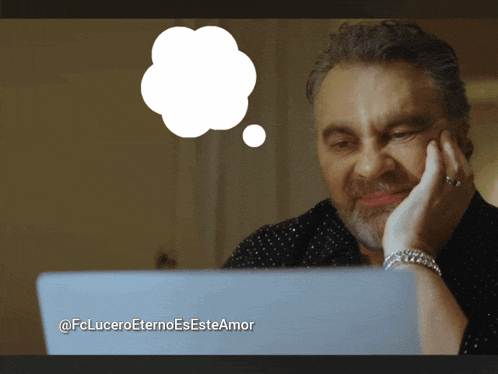 a man sitting in front of a laptop with a thought bubble above his head