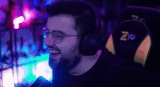 a man wearing headphones and glasses is sitting in a chair with the letter z on the back .