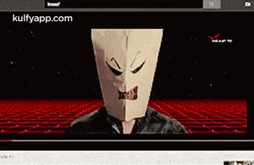 a person wearing a paper bag on their head is looking at the camera .