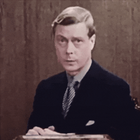 a man in a suit and tie sits at a table