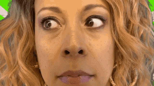 a close up of a woman 's face making a funny face with her eyes closed .