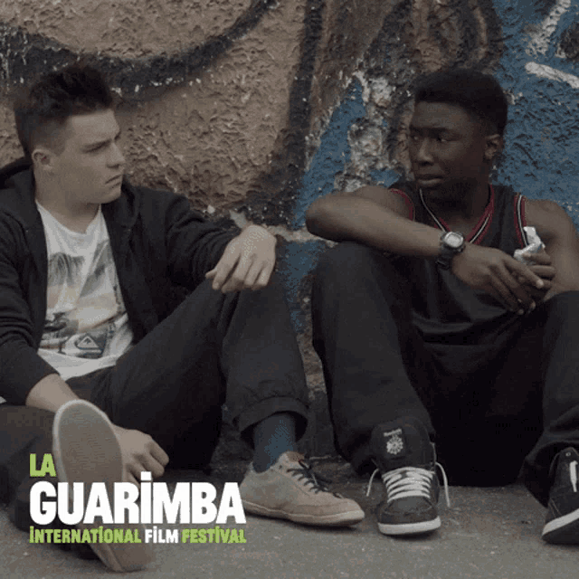 a poster for the la guarimba international film festival shows two young men sitting on the ground