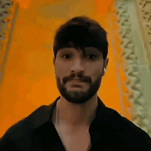 a man with a beard is wearing earbuds and a black shirt
