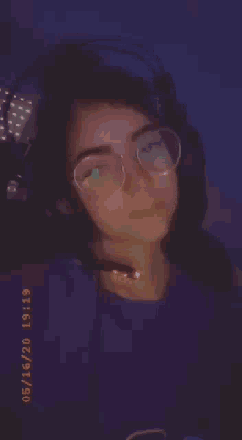 a girl wearing glasses and headphones is taking a selfie on 05/16/20