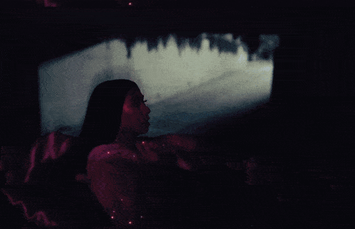 a woman laying on a pink couch with a reflection of a building in the background