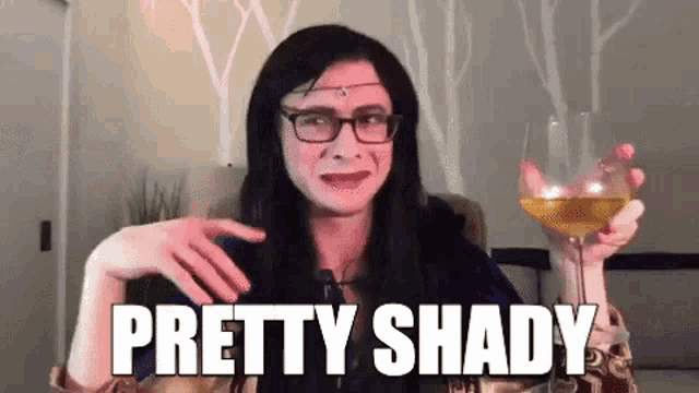 a woman with glasses is holding a glass of wine and saying `` pretty shady '' .