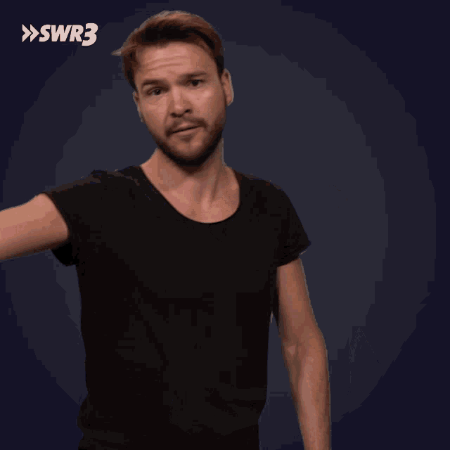 a man in a black shirt is standing in front of a blue background with the letters swr3 on it