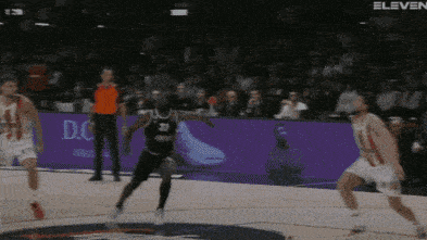 a basketball game is being played in front of a purple banner that says eleven