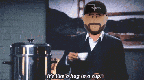 a man with a beard wearing a forum3 hat holds a cup of coffee