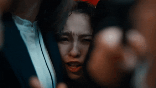 a close up of a woman 's face in a crowd of people