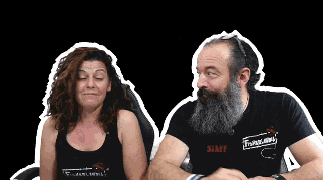 a man and a woman are sitting next to each other and the man has a staff shirt on