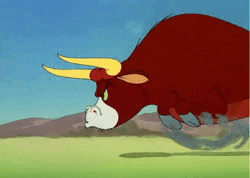 a red bull with yellow horns is running in a field .