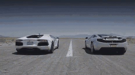 a lamborghini and a mclaren are driving down a desert road