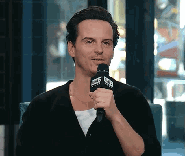 a man speaking into a microphone that says build