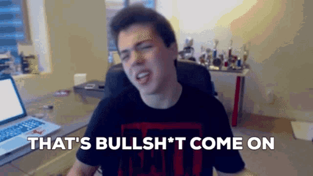 a man sitting in front of a laptop with the words that 's bullshit come on above him