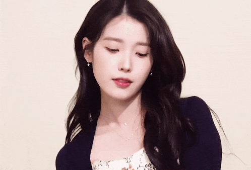 a woman wearing a black cardigan and a white dress