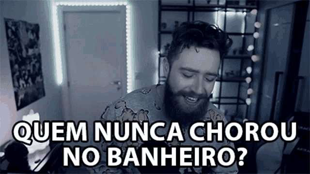 a man with a beard is sitting in a room with the words " quem nunca chorou no banheiro " written above him