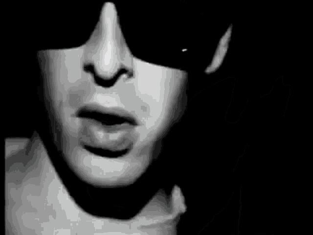 a close up of a woman 's face wearing sunglasses .