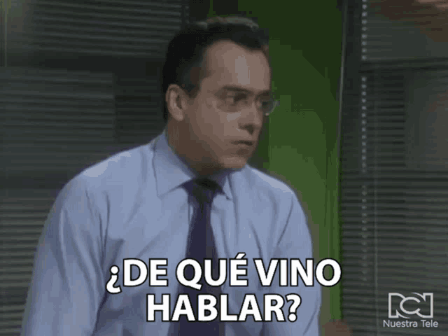 a man in a blue shirt and purple tie is asking " de que vino hablar "