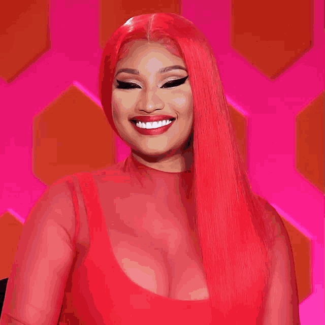 a woman with red hair and a red top smiles