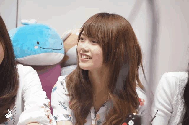 a woman smiles in front of a stuffed animal