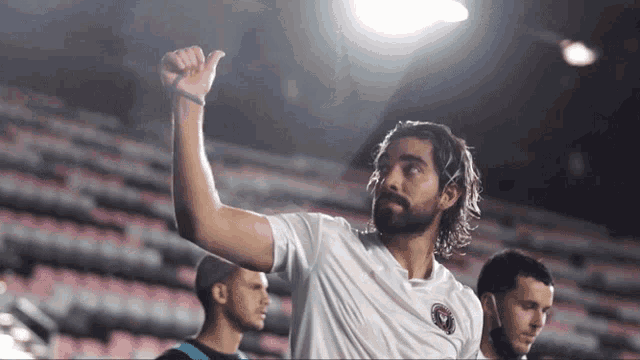 a man with a beard wearing a white shirt with a miami logo on it
