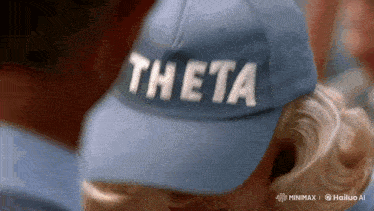 a person wearing a blue hat that says theta
