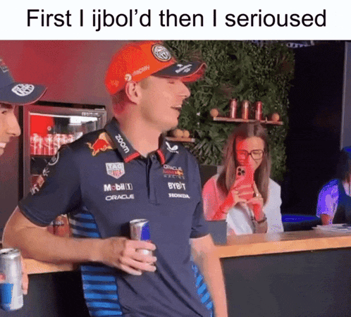 a man wearing a red bull shirt is holding a red bull can