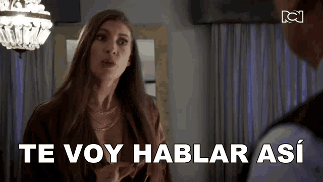 a woman is talking to a man in a room and the words te voy hablar asi are above her