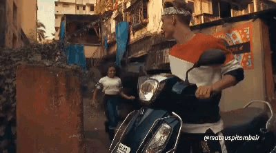a man is riding a scooter with a license plate that says sss on it while a woman stands behind him