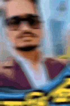 a blurry image of a man wearing sunglasses and a tie