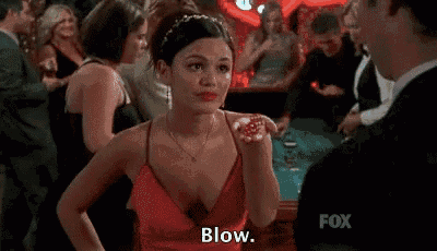 a man in a suit is blowing a kiss to a woman in a red dress .