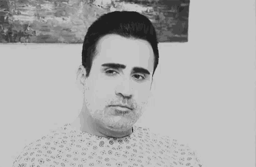 a man in a hospital gown is looking down at something