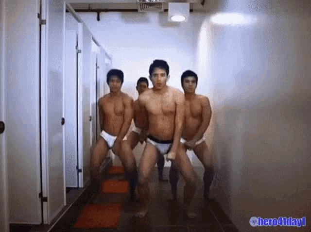 a group of men in underwear are dancing in a hallway with the words hero4day1 on the bottom