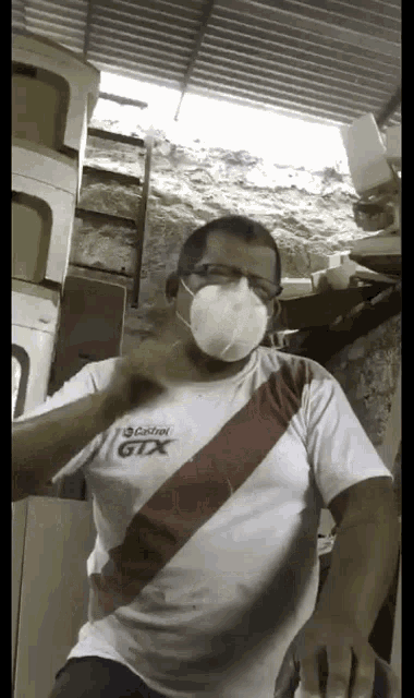 a man wearing a castrol gtx shirt and a mask