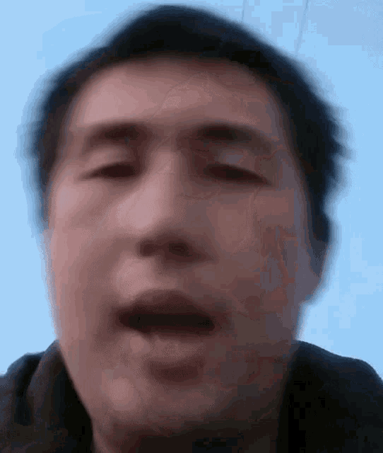a man 's face is shown in a blurry photo with his mouth open