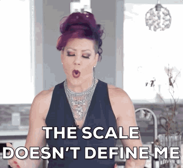 a woman with purple hair is making a funny face and says the scale does n't define me